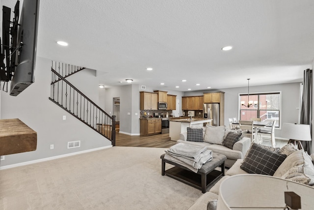 carpeted living room featuring a chandelier