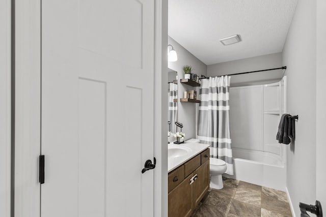 full bathroom featuring shower / tub combo with curtain, vanity, a textured ceiling, and toilet