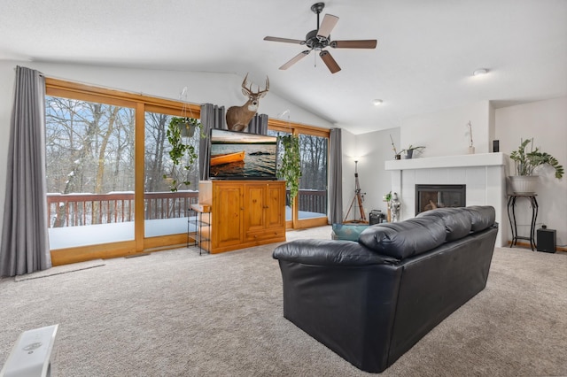 living room featuring light carpet, vaulted ceiling, a tile fireplace, and ceiling fan