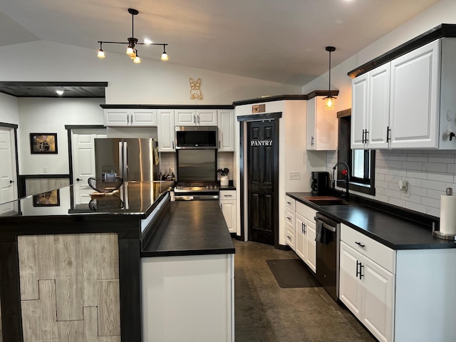 kitchen featuring pendant lighting, appliances with stainless steel finishes, lofted ceiling, and sink