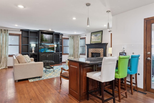 living room with bar, a fireplace, and hardwood / wood-style flooring