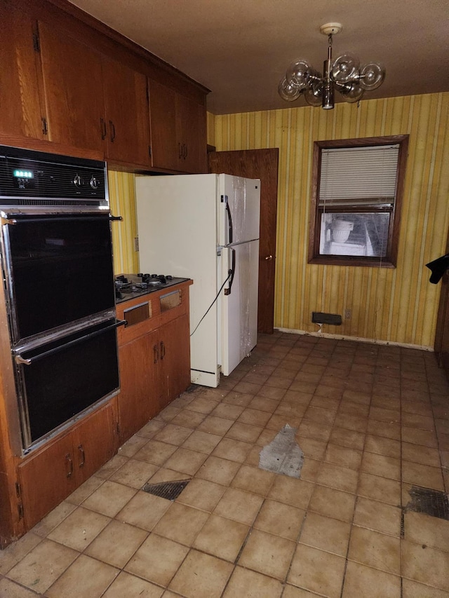 kitchen with double oven, a chandelier, gas stovetop, and white refrigerator