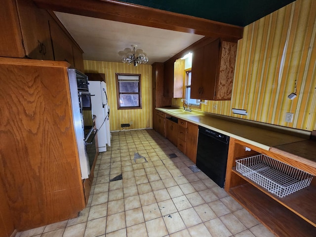 kitchen featuring sink, white refrigerator, an inviting chandelier, black dishwasher, and wood walls