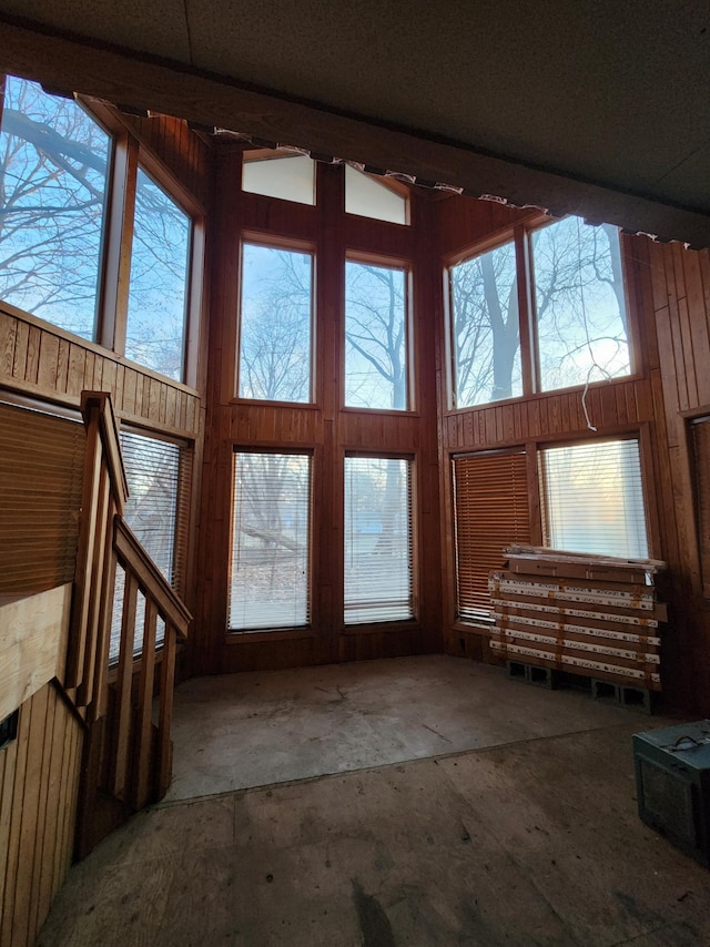 interior space featuring a towering ceiling and wood walls