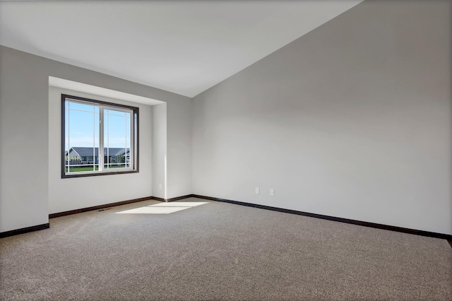 empty room featuring carpet floors and lofted ceiling