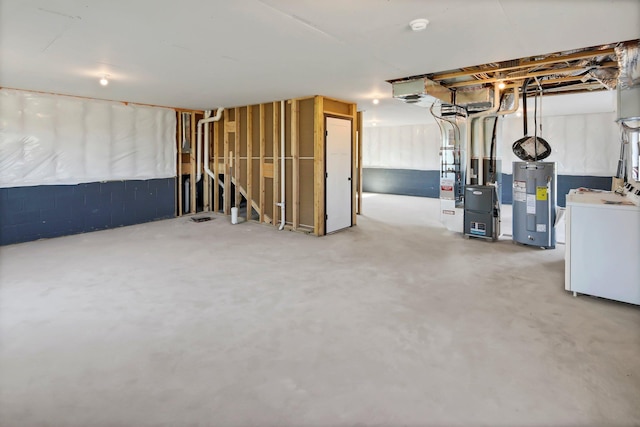 basement featuring electric water heater and washer / clothes dryer