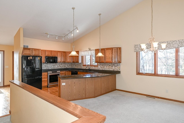 kitchen with pendant lighting, kitchen peninsula, backsplash, and black appliances