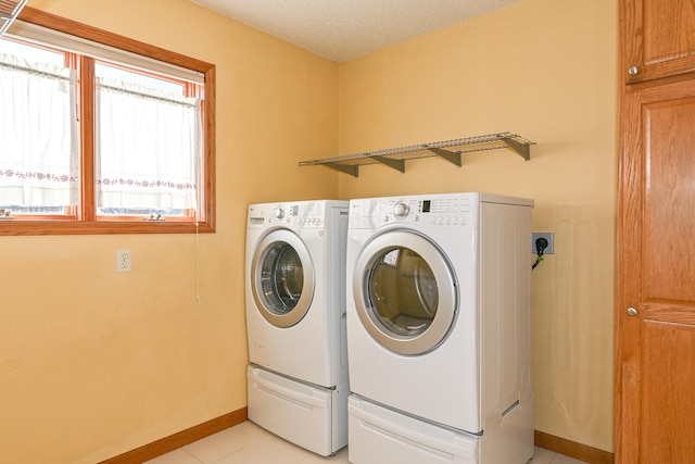 laundry room with light tile patterned floors and washing machine and dryer