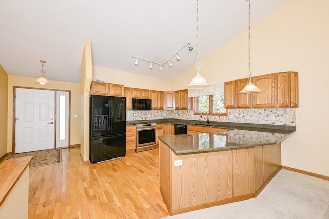 kitchen with a sink, black appliances, backsplash, a peninsula, and pendant lighting
