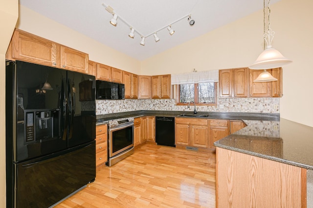 kitchen featuring black appliances, a sink, light wood-style flooring, and tasteful backsplash