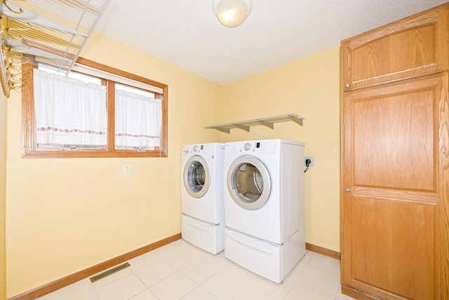 clothes washing area featuring baseboards, visible vents, laundry area, and independent washer and dryer