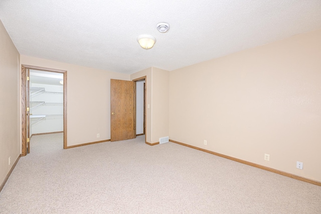 interior space with visible vents, light colored carpet, and baseboards