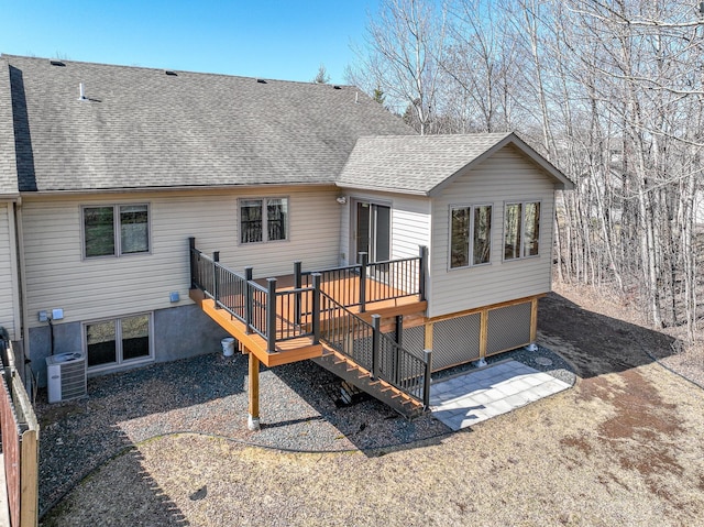rear view of house featuring a deck, a shingled roof, a patio area, central AC, and stairs