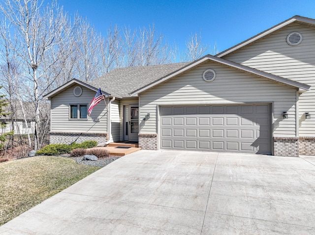 view of front of property with roof with shingles, concrete driveway, an attached garage, and brick siding