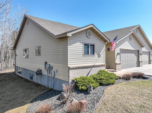 exterior space with brick siding, driveway, a shingled roof, and a garage