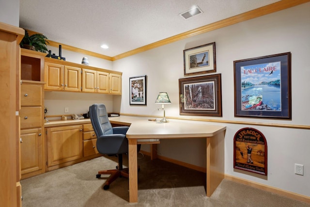 carpeted office featuring built in desk, a textured ceiling, and ornamental molding