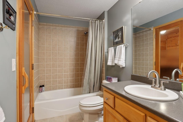 full bathroom featuring shower / bath combo, tile patterned floors, vanity, a textured ceiling, and toilet