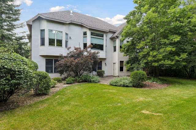 rear view of property featuring a lawn