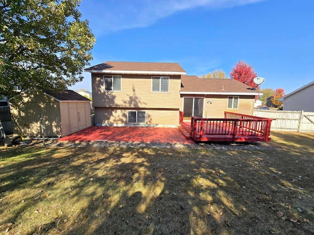 back of house featuring a lawn, a wooden deck, and a storage shed