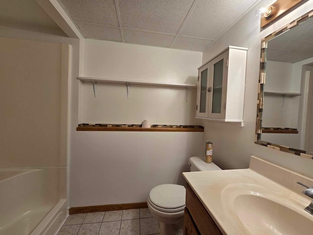 bathroom featuring tile patterned floors, a drop ceiling, toilet, and vanity