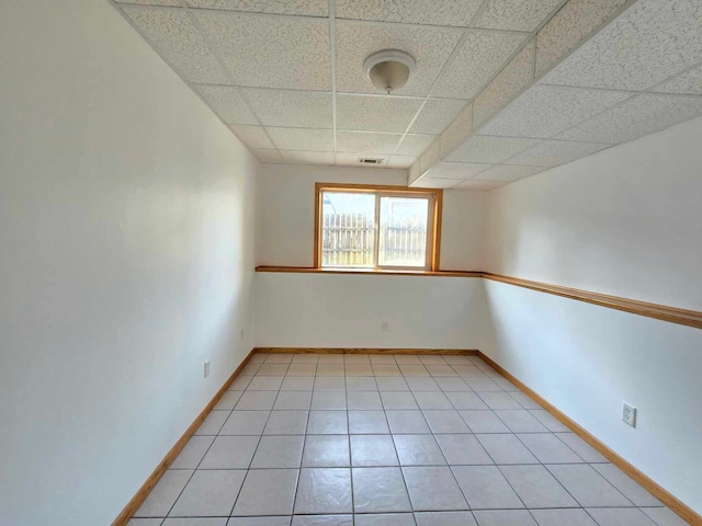 tiled spare room featuring a paneled ceiling