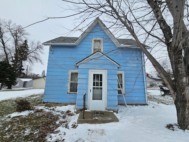 view of snow covered back of property