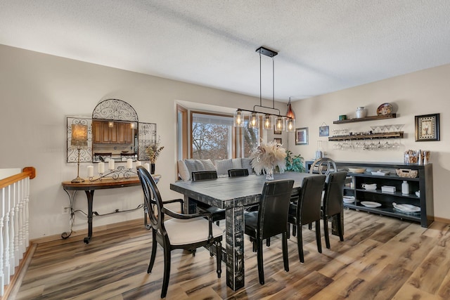 dining room featuring hardwood / wood-style floors and a textured ceiling