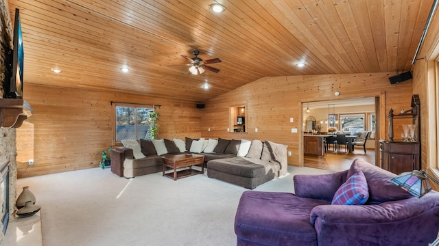 living room with wooden walls, a fireplace, wood ceiling, and lofted ceiling