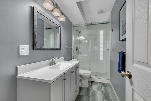 bathroom with vanity, toilet, and an enclosed shower