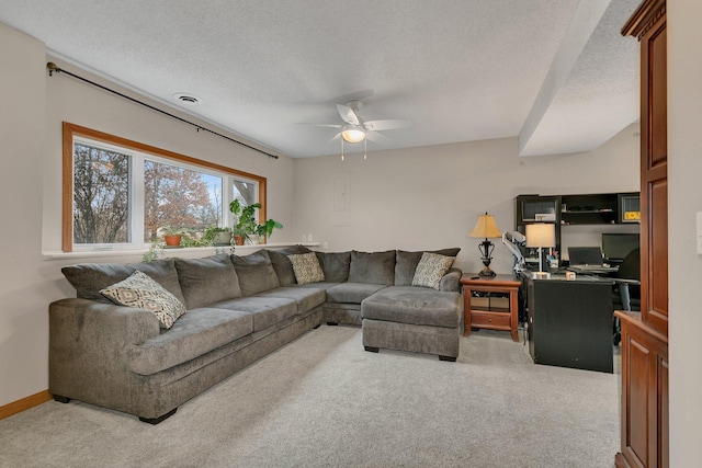 living room with ceiling fan, carpet, and a textured ceiling