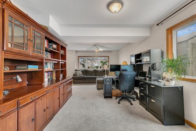 carpeted home office featuring ceiling fan and a textured ceiling