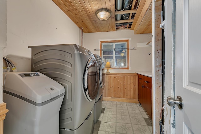 clothes washing area featuring wood ceiling, separate washer and dryer, and wooden walls