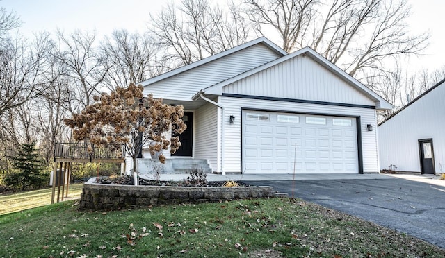 view of front of house featuring a front yard, a garage, and a wooden deck