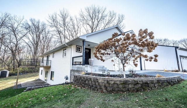 view of front of property with a garage, an outbuilding, and a front yard