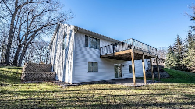 back of property featuring a deck, a patio area, and a lawn