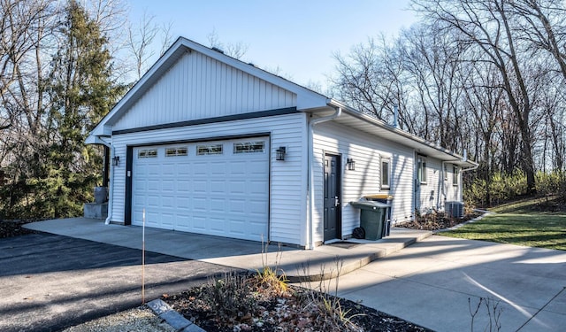 view of side of home featuring a garage, an outbuilding, and central AC