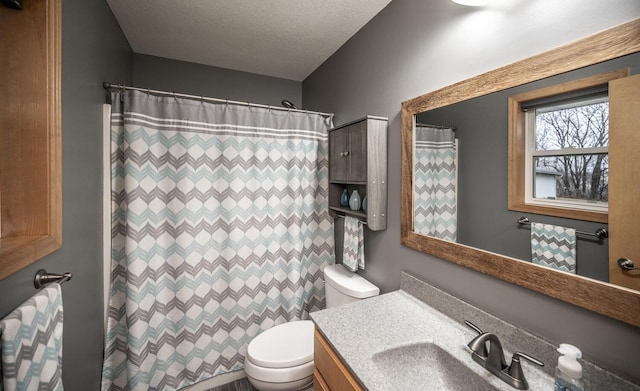 bathroom featuring curtained shower, vanity, a textured ceiling, and toilet