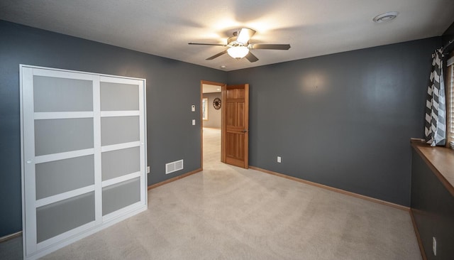 unfurnished bedroom featuring ceiling fan and light colored carpet