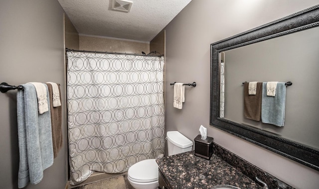 bathroom featuring curtained shower, vanity, a textured ceiling, and toilet