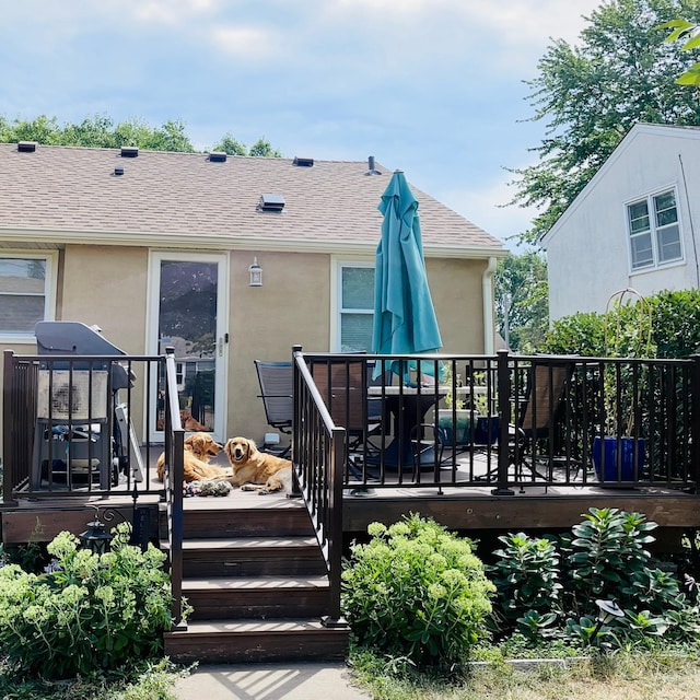 rear view of property featuring a wooden deck