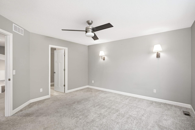 spare room with ceiling fan and light colored carpet