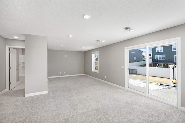 carpeted spare room with a textured ceiling