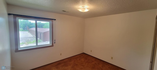 carpeted empty room with a textured ceiling