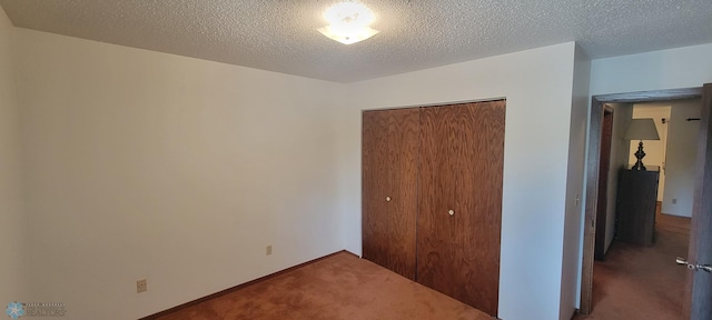 unfurnished bedroom featuring carpet flooring, a textured ceiling, and a closet