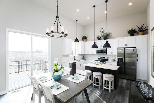 dining room featuring sink, a high ceiling, and a chandelier