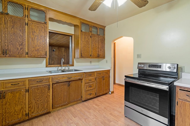 kitchen featuring ceiling fan, electric range, sink, and light hardwood / wood-style flooring