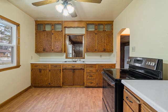 kitchen with stainless steel electric stove, sink, ceiling fan, and light wood-type flooring