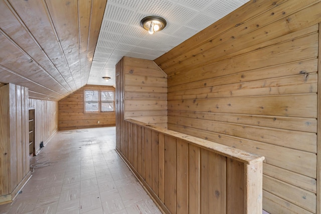 hallway featuring vaulted ceiling, wooden walls, and wooden ceiling