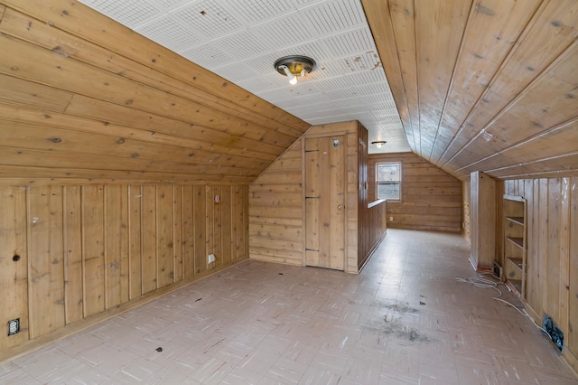 additional living space featuring vaulted ceiling, wood ceiling, and wood walls