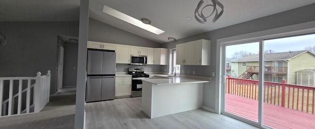 kitchen with kitchen peninsula, white cabinetry, sink, and stainless steel appliances